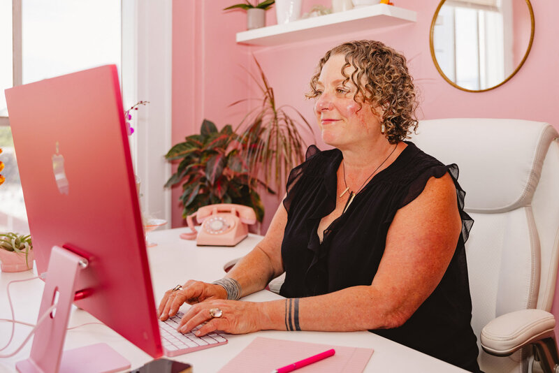 Oregon business lawyer Cassie smiles while working at her computer in her Eugene Oregon law office.
