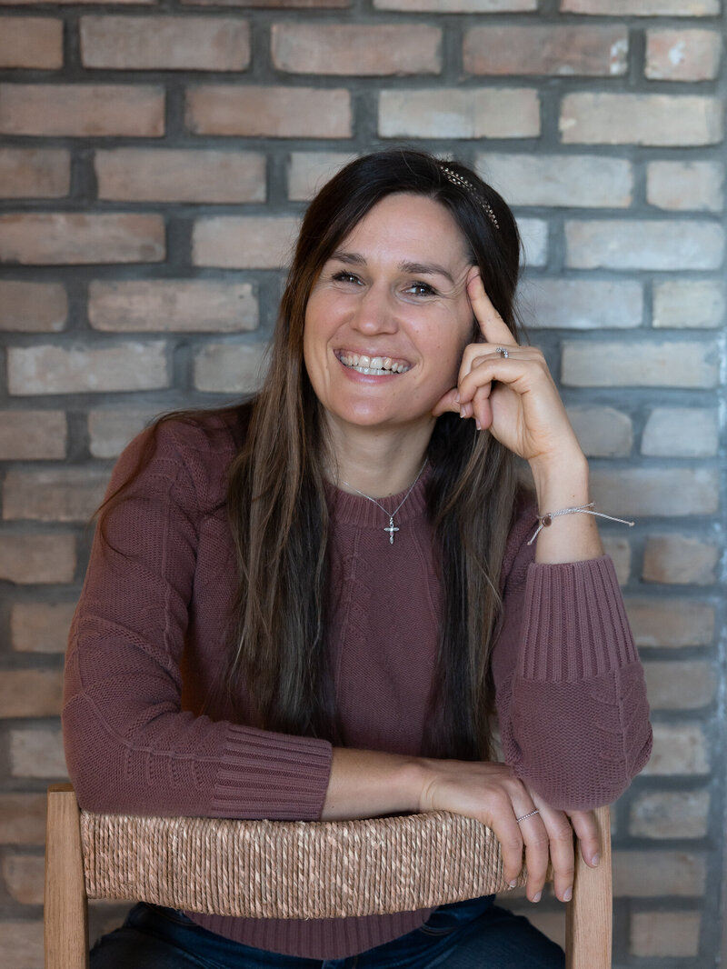 Jasmin smiling while sitting on the ground