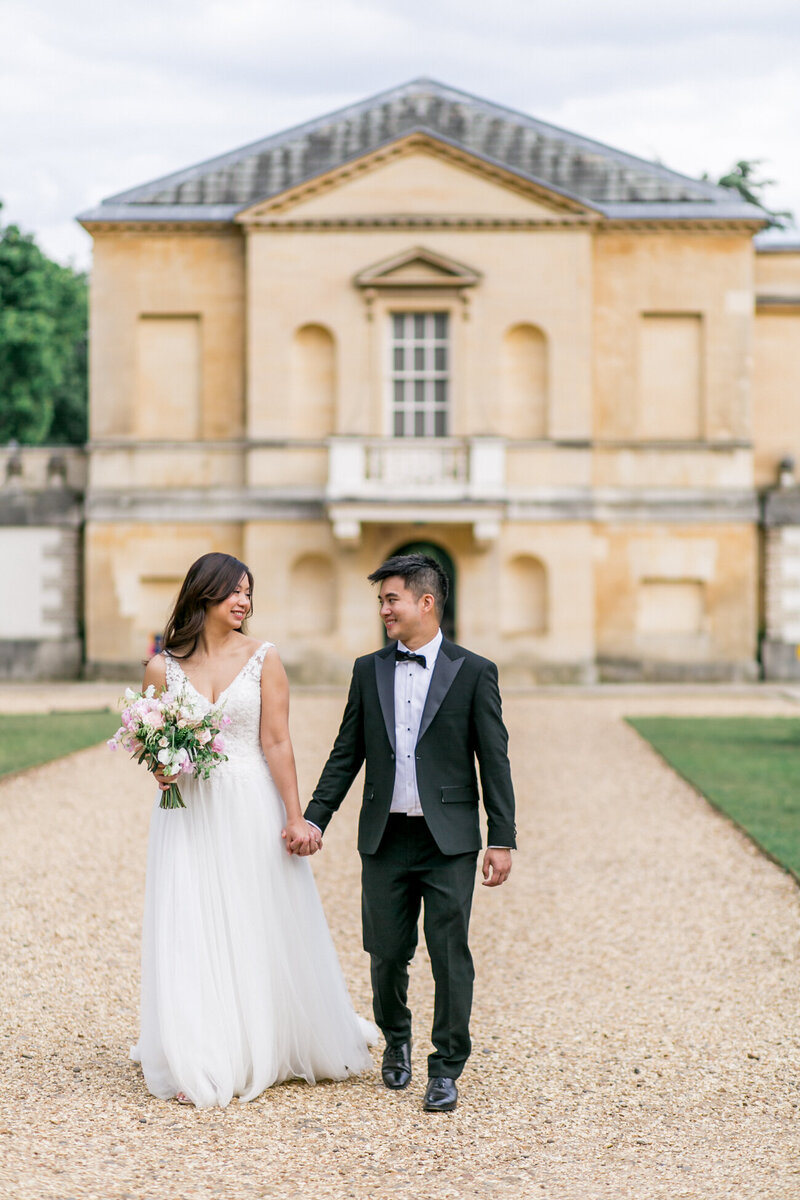 Asian bride and groom walking hand in hand at their black tie wedding at Chiswick House and Gardens, London