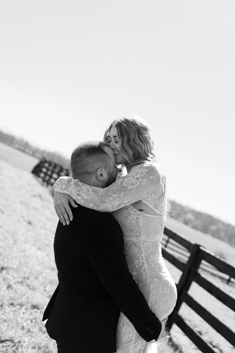 Playful moment of a couple dancing as they spin near a Kentucky farm during their engagement session.