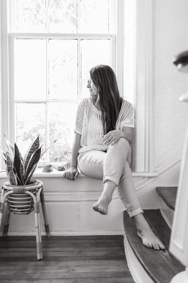Picture of San Antonio photographer Cassey Golden sitting in the window on her front porch.