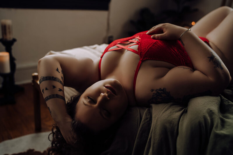 Curvy woman posing  with back over the edge of bed for boudoir shoot
