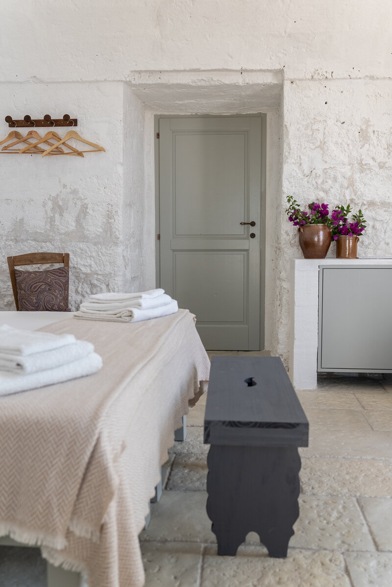 White Italian hotel with arched doorways and pots out front