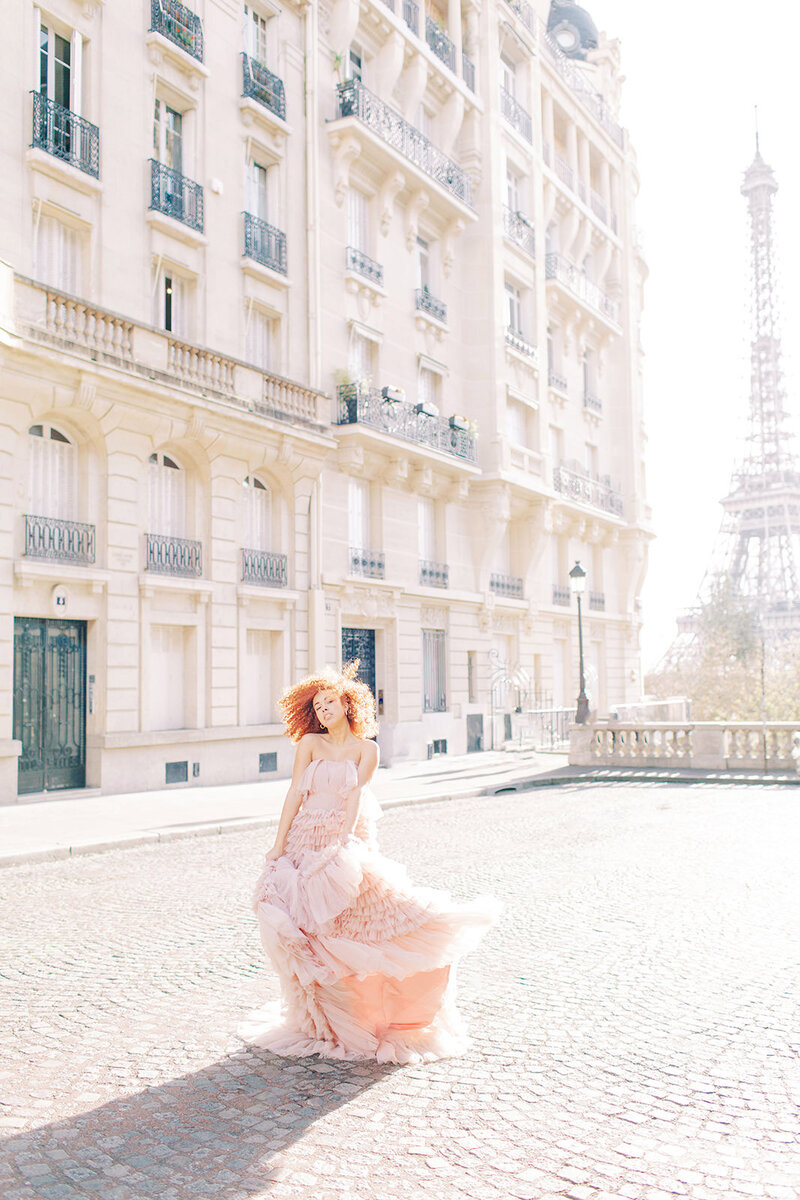 Wedding Photographer,  a woman in a dress walks on streets before Eiffel Tower