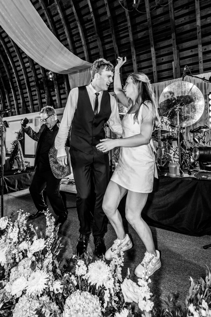 Spring wedding at WinMock at Kinderton, designed by Charming Carolina — bride and groom singing and dancing on the band’s stage during the reception celebration.