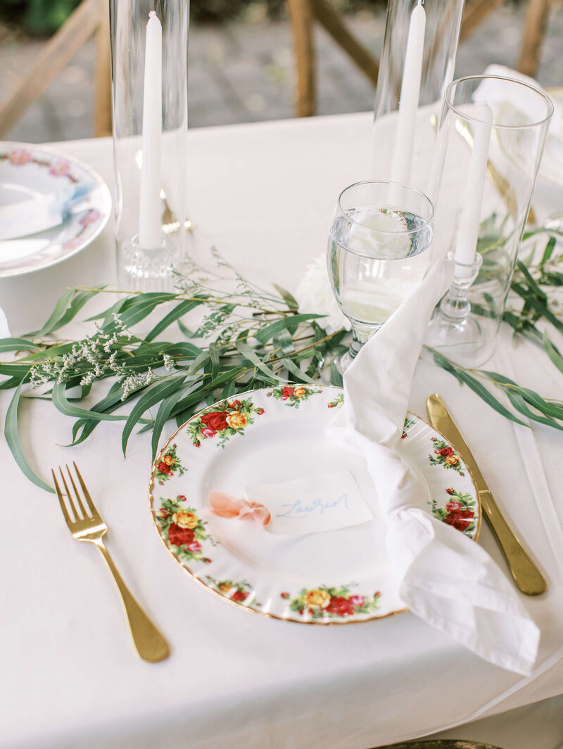 Table setting with candles and vintage china at a luxury backyard wedding by Eugene wedding planners Birdie June Events & Rentals. 