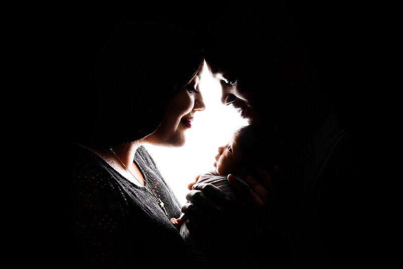 Baby boy with parents for backlit silhouette family photos