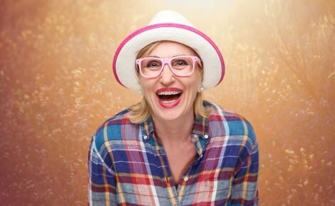 Middle Age Woman with a hat and glasses  laughting and enjoying life.