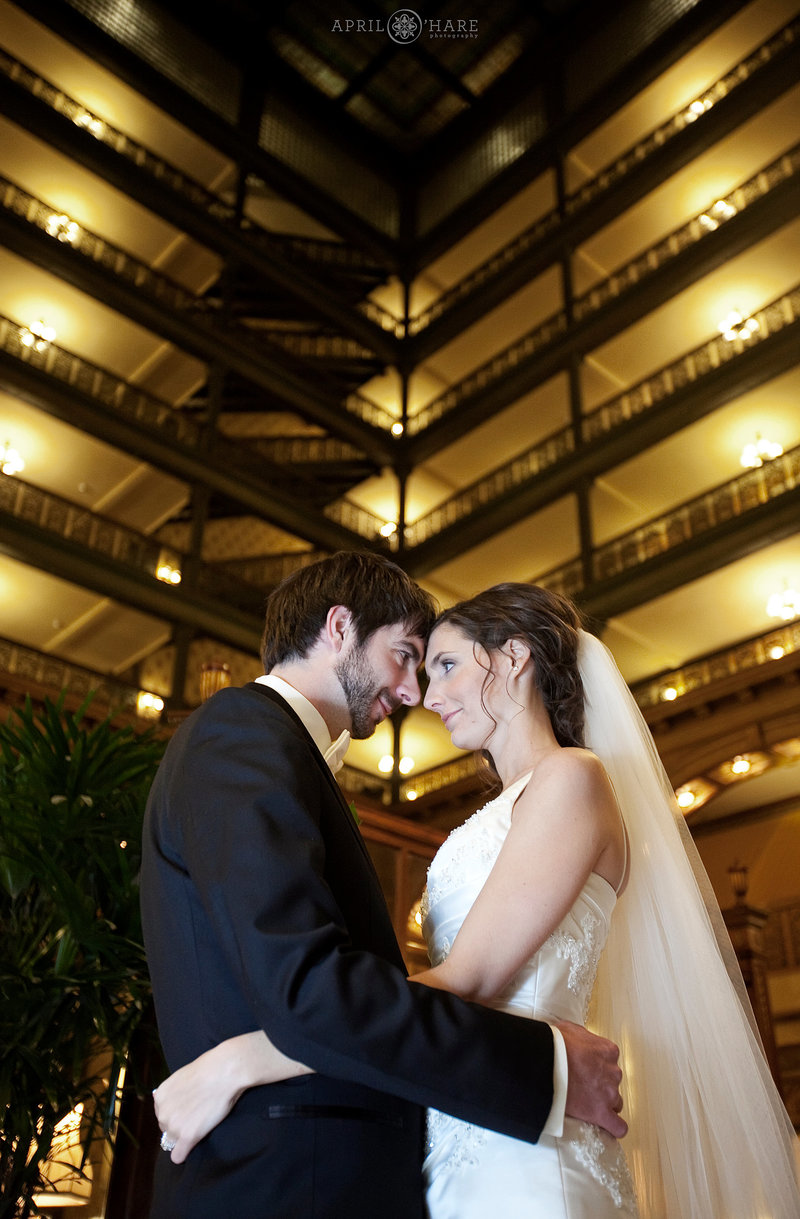 Bride and Groom pose with Brown Palace Atrium in the backdrop in Denver CO