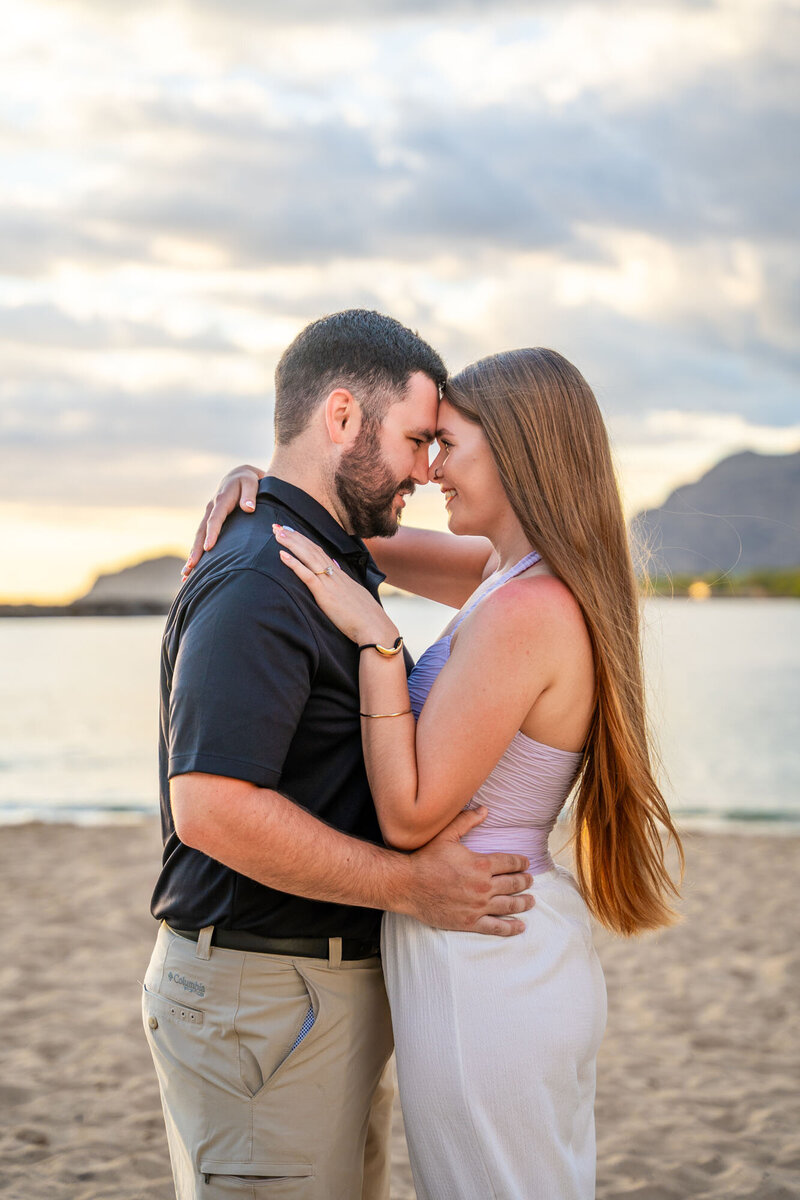 Couple touching foreheads on beach, by photographer on the big island of hawaii