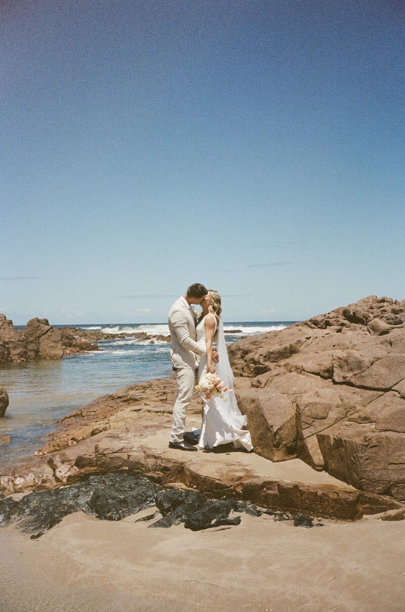 Film photography of couple kissing on the beach at Talm Beach House, Port Stephens
