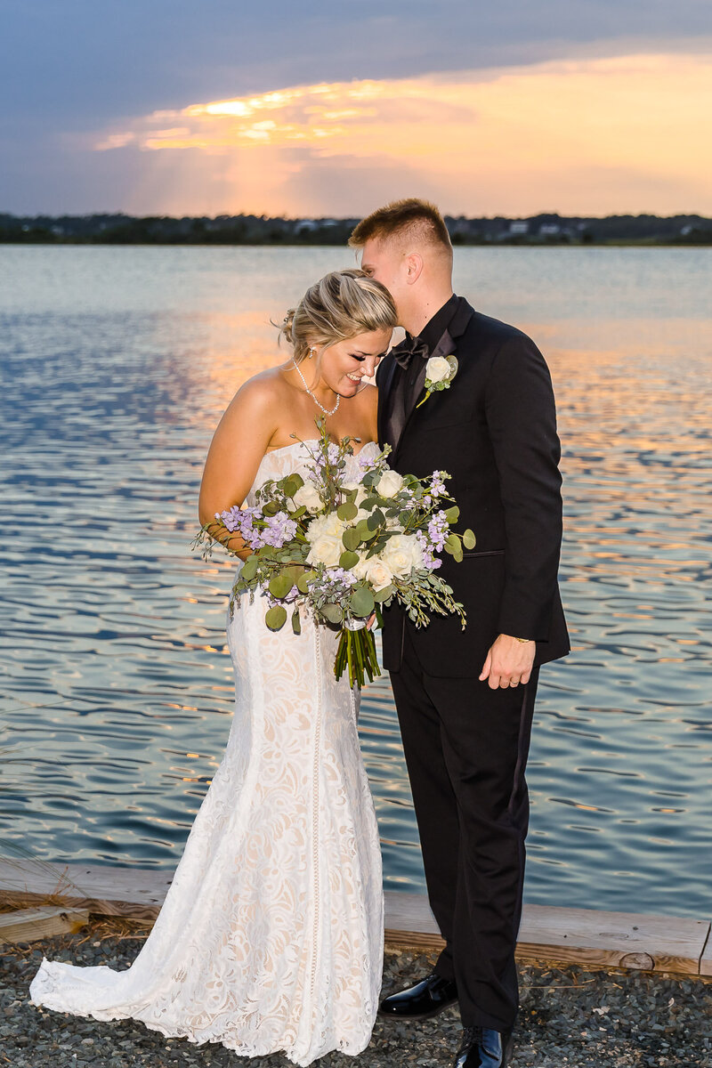 "Newly married couple share an embrace at sunset after wedding ceremony on Topsail Island"