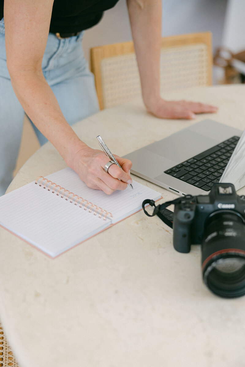 Zelda Green, photographer and educator, working on her business and on her laptop