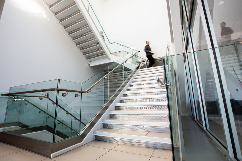 Stairwell with glass railings and figure in motion