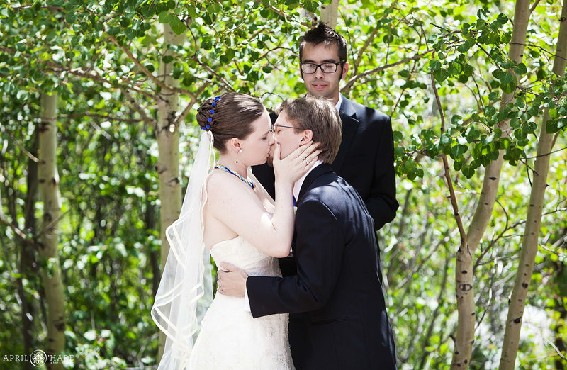 Ceremony kiss at River Run outdoor ceremony site at Wild Basin Lodge in Allenspark Colorado