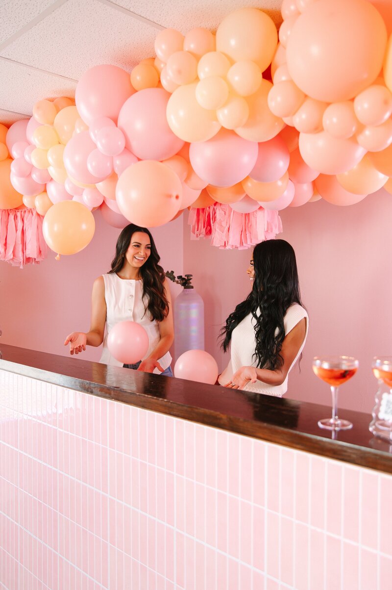 RVA balloon decor vendor Emily places a pink balloon arch.