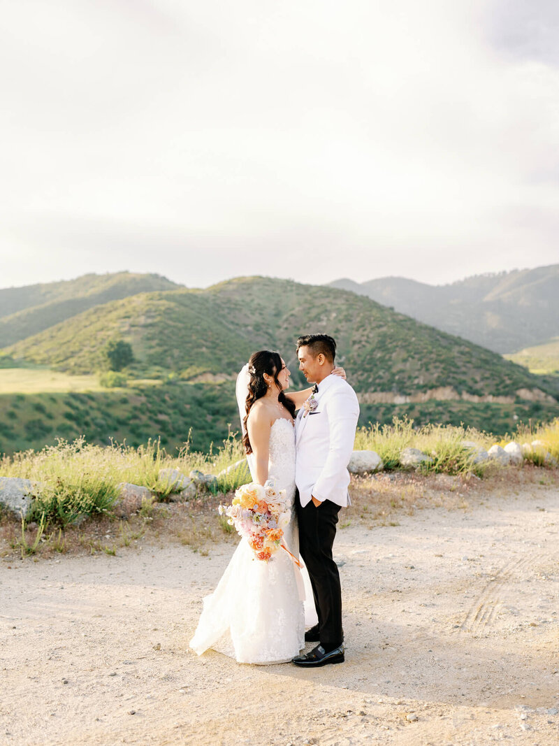 outdoor timeless romantic sunset wedding photography of couple facing each other with beautiful mountain view