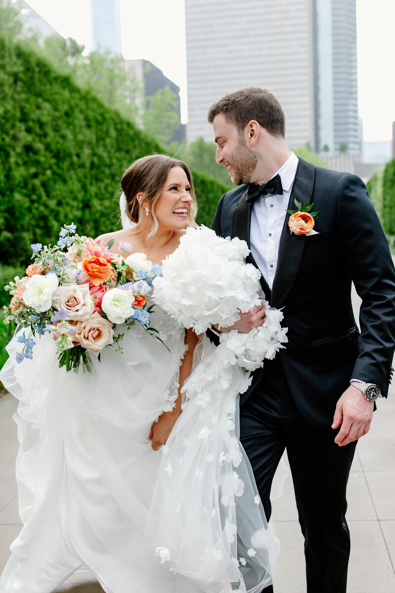 Two grooms embrace surrounded by candlelight at their wedding reception