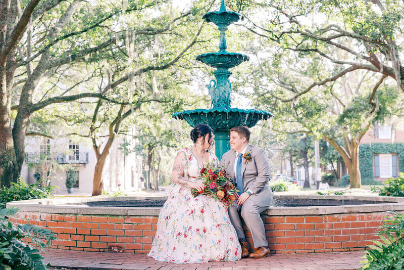The couple shares a tender embrace during their portrait session at Forsyth Park, surrounded by Savannah's natural beauty.