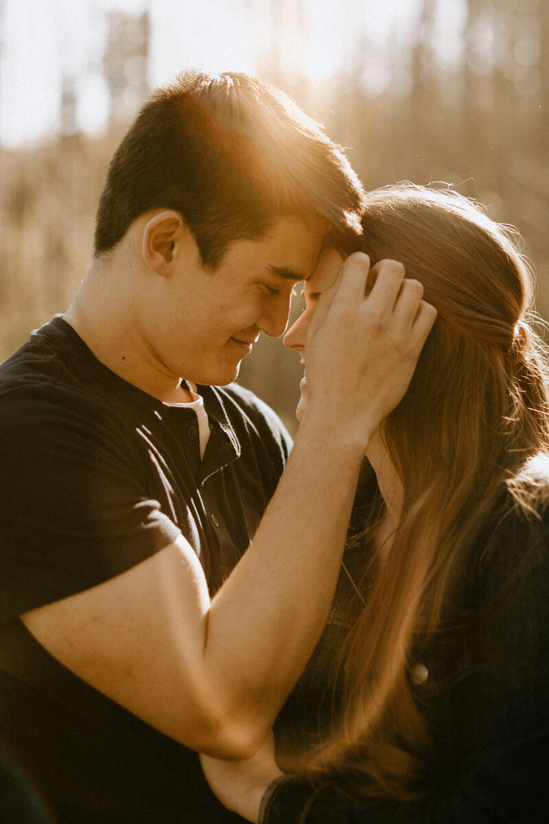 Close-up photo of a couple holding each other at sunset
