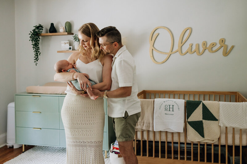 A natural light portrait taken of a couple holding their newborn son in his nursery in St. Louis, Missouri. 