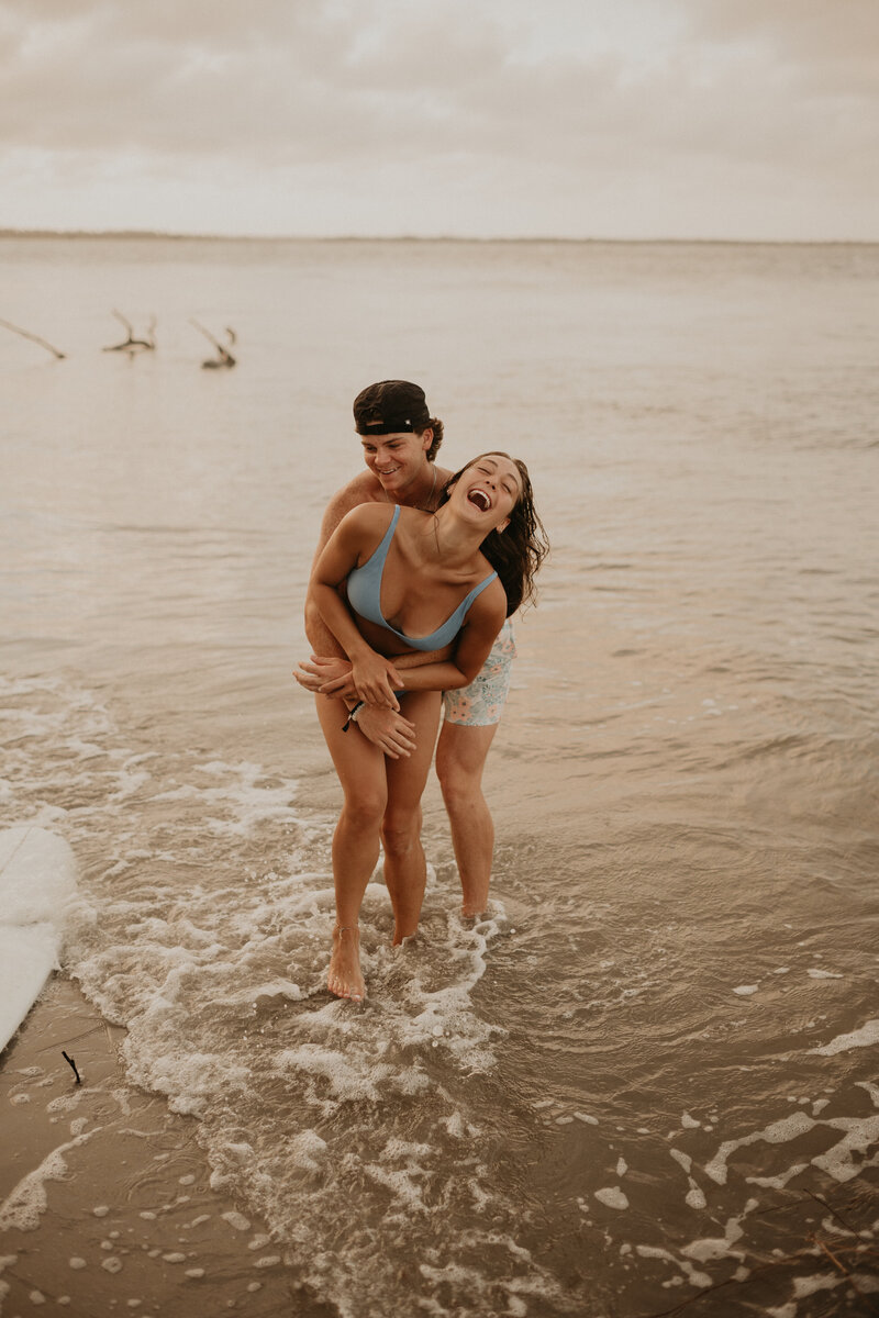 man holding girl on the beach