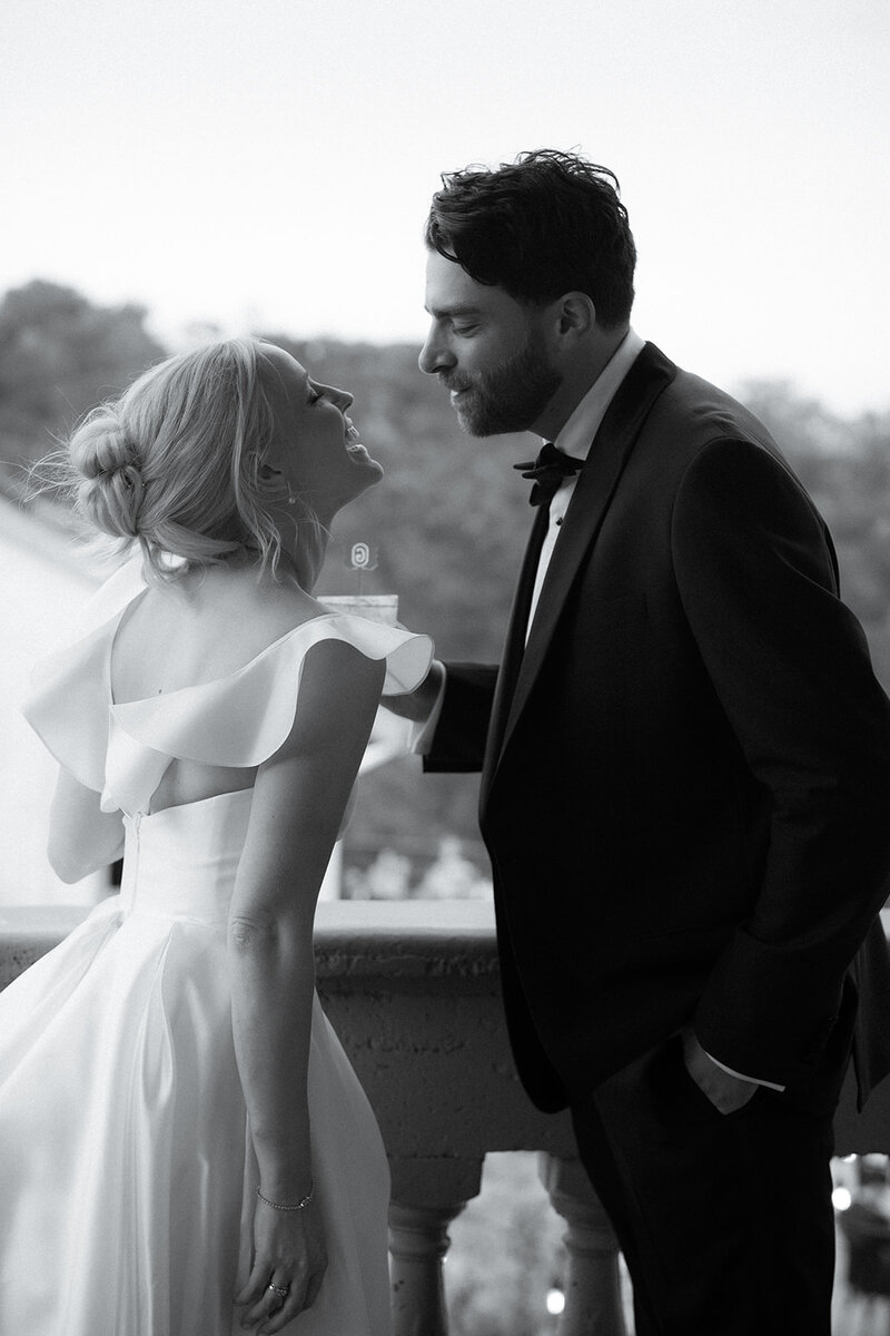 Photograph of bride and groom smiling at each other