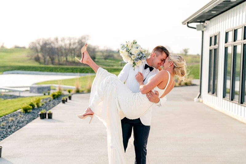 Beautiful bride and groom holding hands at a rustic wedding venue in Cedar Rapids. Captured by Chelsea Peery Photography, specializing in natural, true-to-color wedding photography that highlights the unique charm of each celebration.