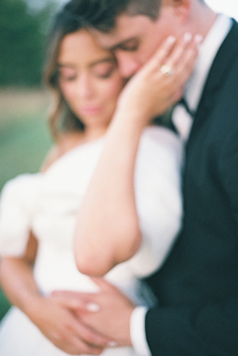 film photo of a knoxville marblegate wedding with bride and groom holding on another camera is out of focus making a soft portrait