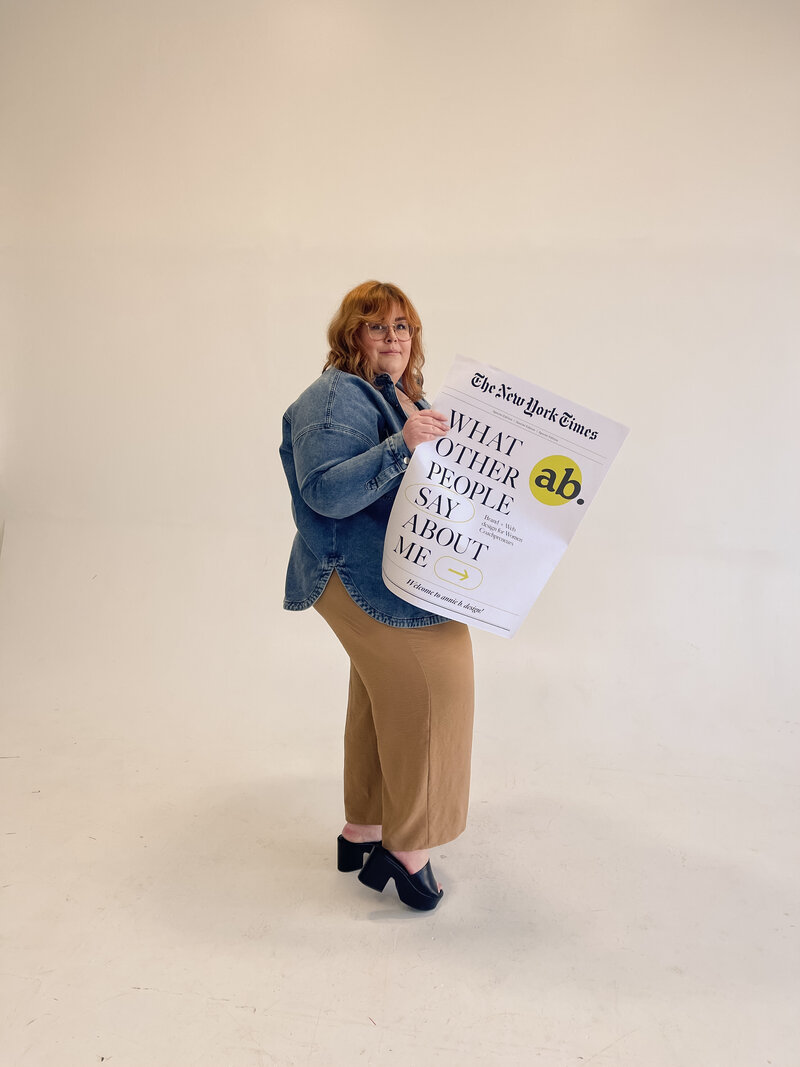 Web designer, annie b. holding a sign that says, "what other people say about me"
