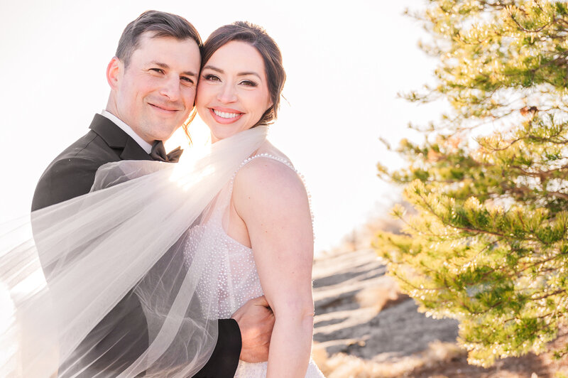 A happy and smiling bride and groom at sunset at The Cliffs at Glassy Chapel enjoying their golden hour portraits by destination wedding photographer, JoLynn Photography