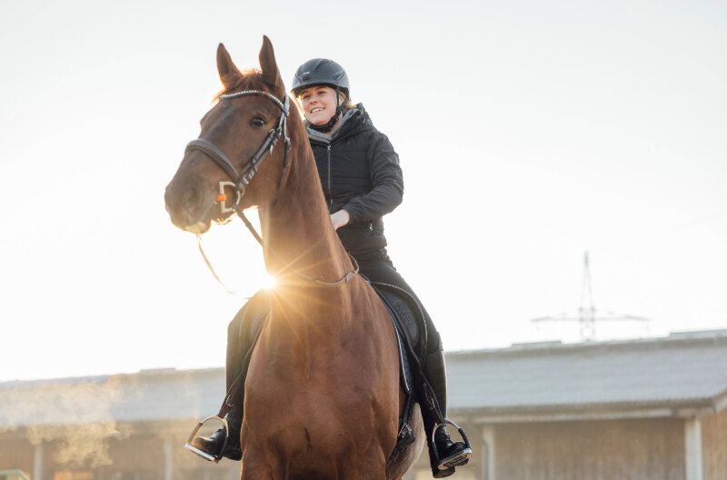 Marie-Louise Kosmatsch sitzt auf dem Rücken ihres Pferdes - Reitunterricht in Vorarlberg