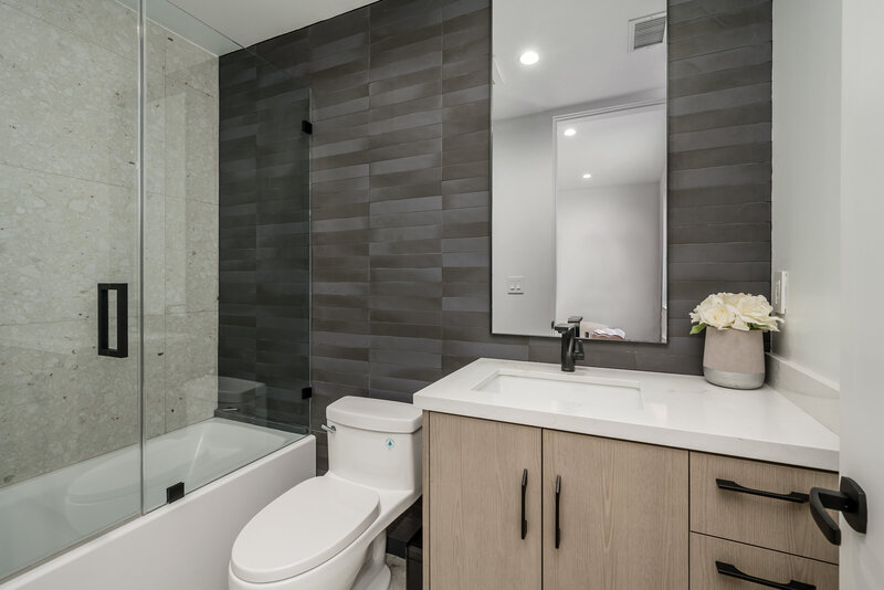 Chic modern bathroom design with glass shower doors and sleek and modern cabinetry.