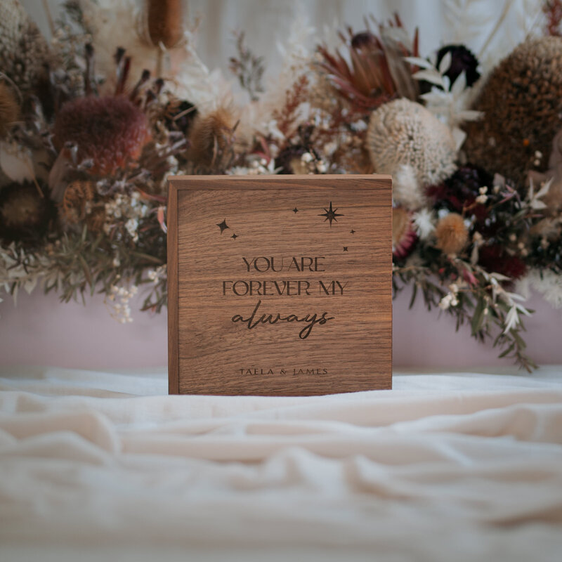 Custom engraved timber box in front of dried flower arrangement