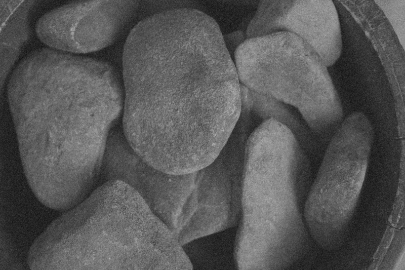 Close-up of a bucket filled with earthy, textured rocks, symbolizing the grounded, tangible energy of the FUTURE Directional Calling in CPTSD Medicine—embodying integrated wholeness, authentic presence, and manifesting life's abundance through the body.
