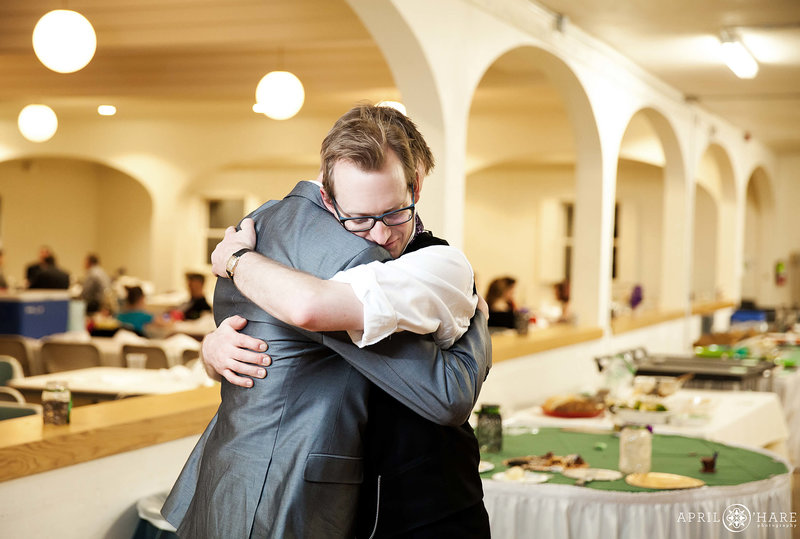 Groom hugs a friend on his wedding day inside Club Tico wedding venue in Fort Collins