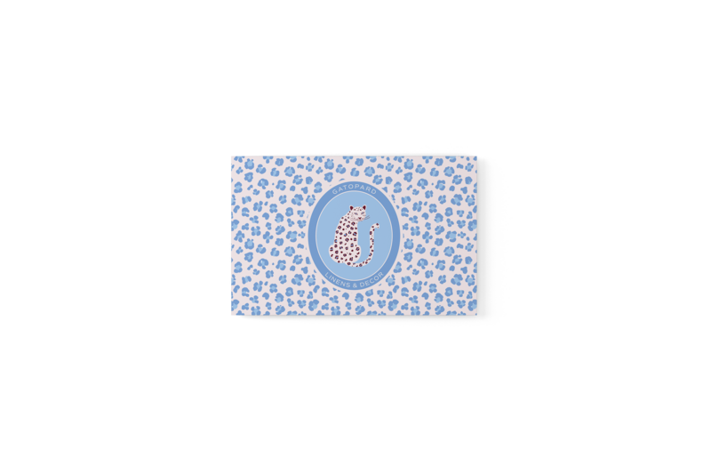 Business Card with blue-toned leopard print on blush background and Gatopard Linens & Decor oval emblem logo in center