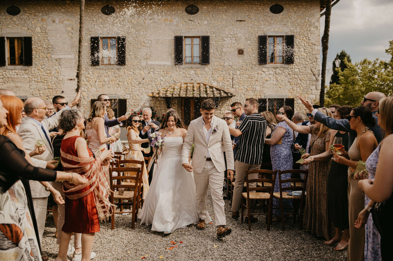 Bride and Groom exiting their destination wedding ceremony as guests toss rice