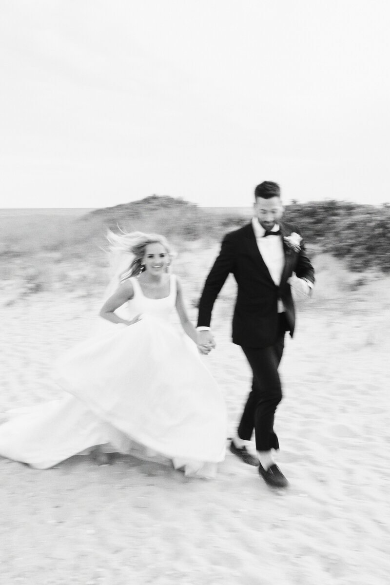 bride raises bouquet in excitement as she walks down aisle with her husband at Newport Wedding