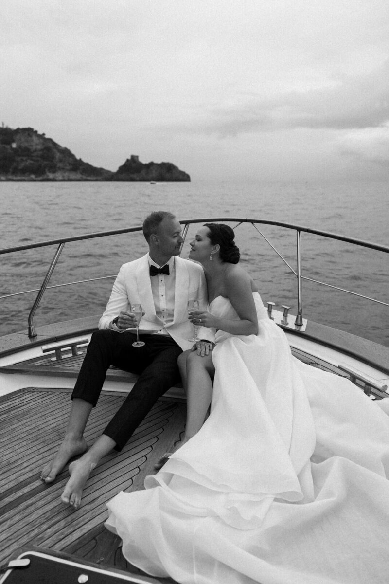 Bride and Groom cuddling together on their private yacht off the coast of Positano Italy on the Amalfi Coast, photographed by Andrea-Marie Photography