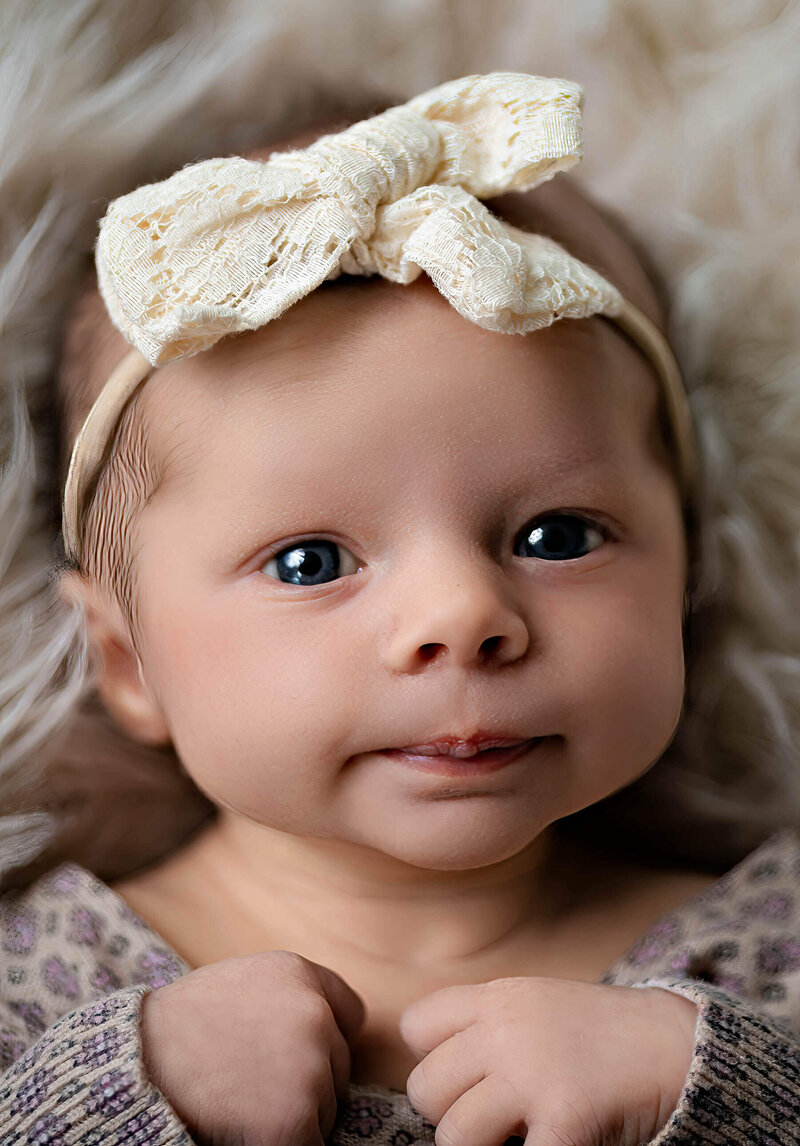 Newborn baby girl with bow on her head