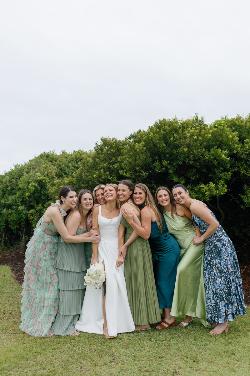 Bridesmaids laugh together as they walk the grounds of the Dunes Country club overlooking the ocean