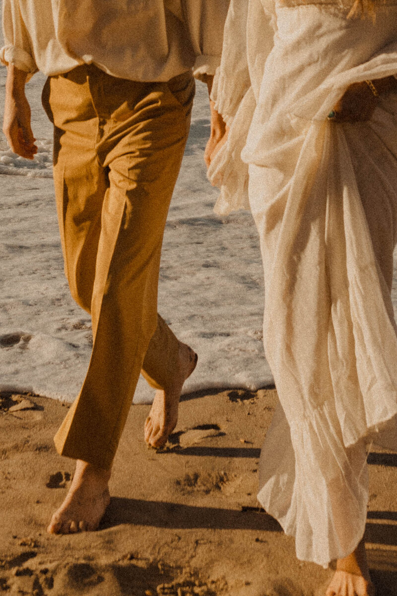 couple running along the beach barefooted