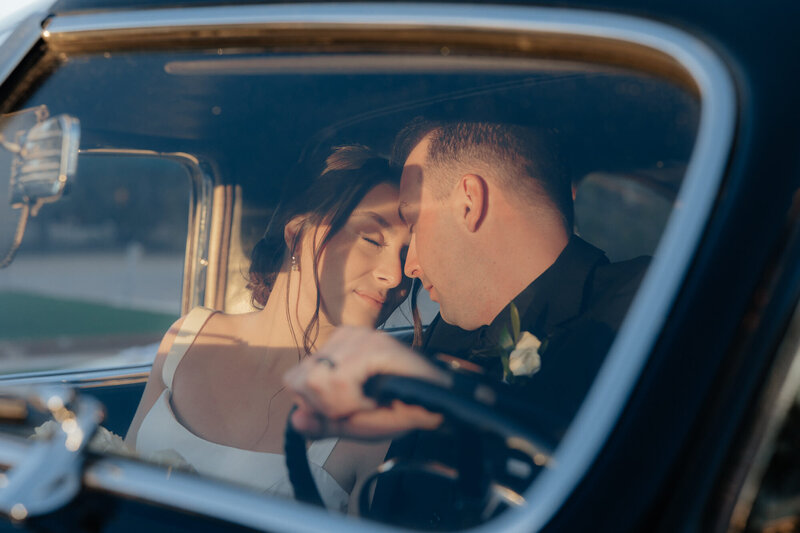 Windmill Winery Florence Arizona Wedding Photographer and Videographer Couple Touching Foreheads Inside Vintage Car