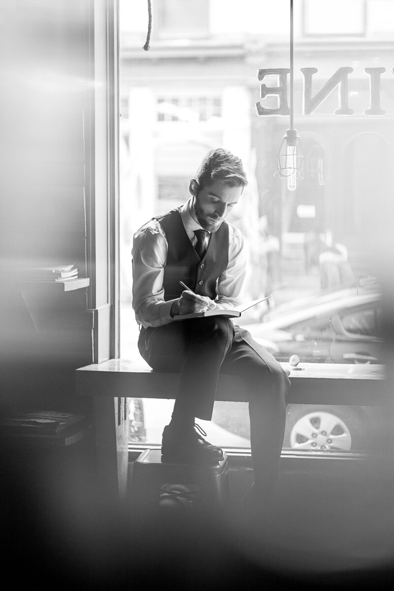 male posing against window with book in upstate ny