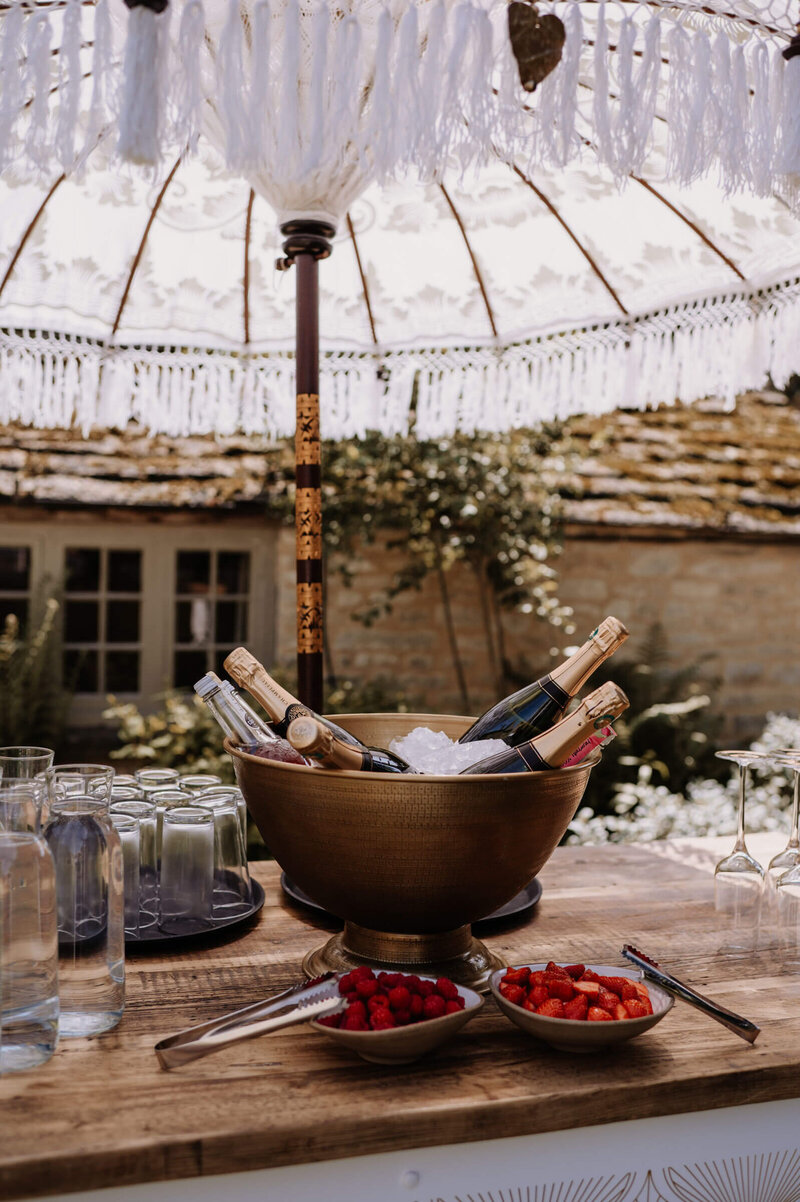 Outdoor cocktail hour setup with champagne and catering at Caswell House