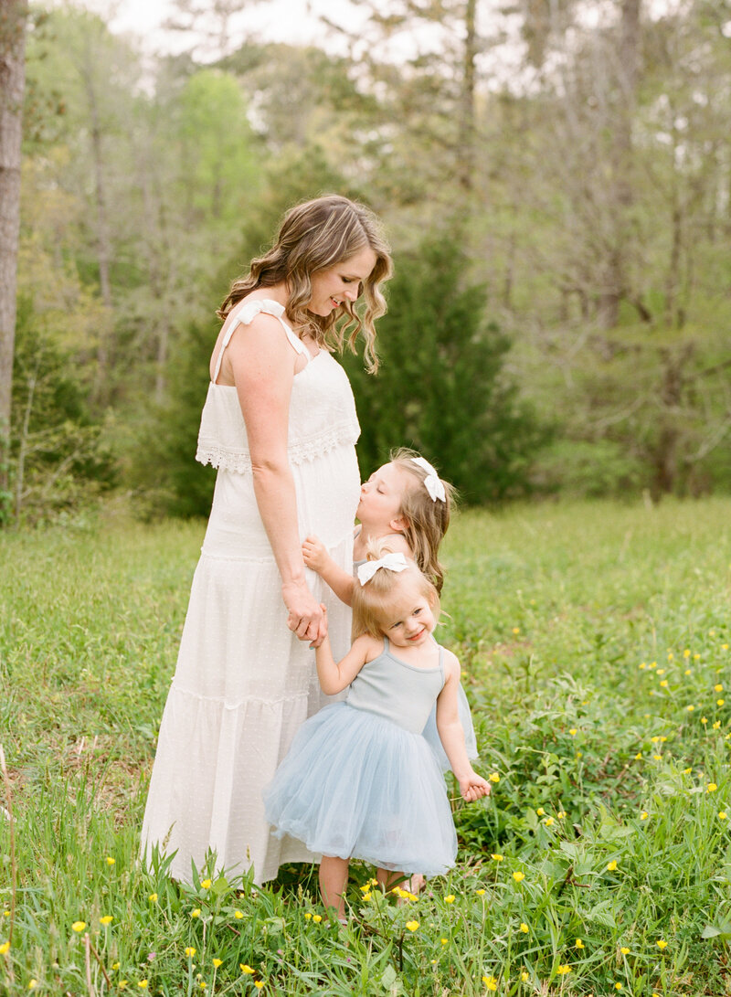 Toddlers kissing pregnant mom on the belly. Image by Raleigh family, maternity & newborn photographer A.J. Dunlap Photography.