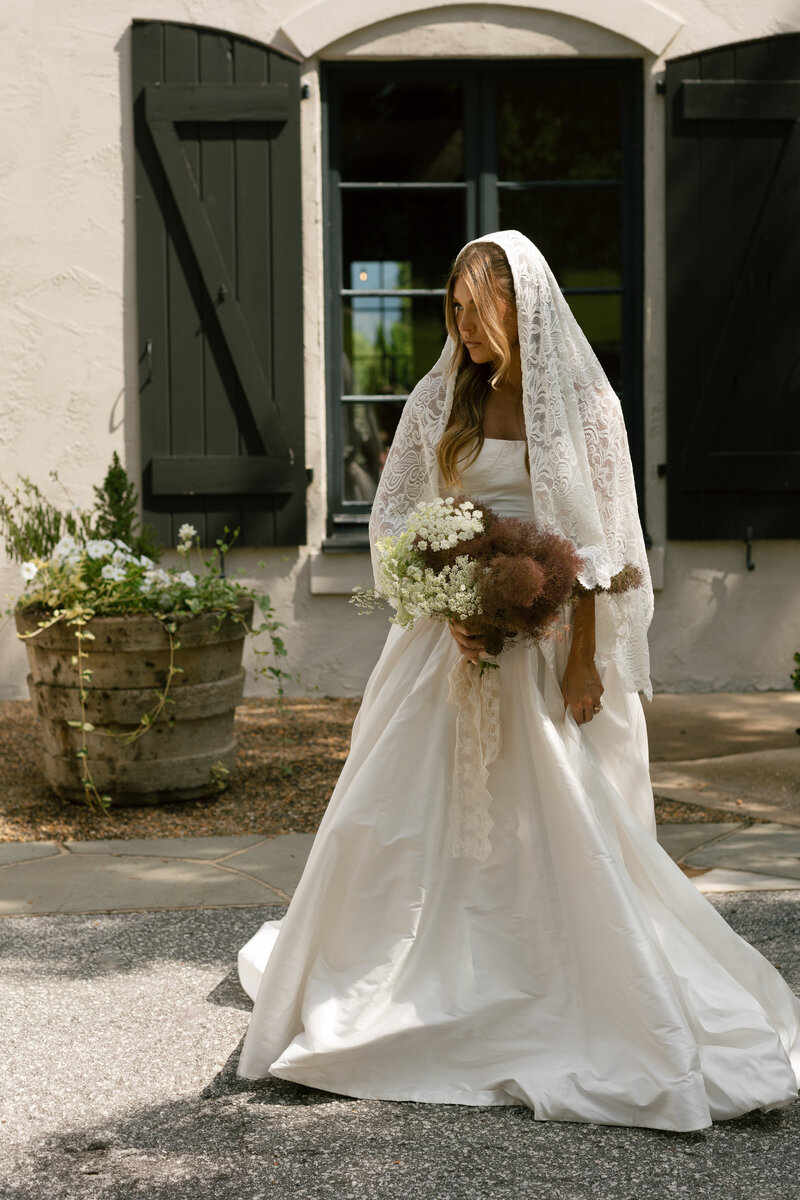 Bride posing gracefully in a flowing gown on Hotel Domestique’s lush grounds.