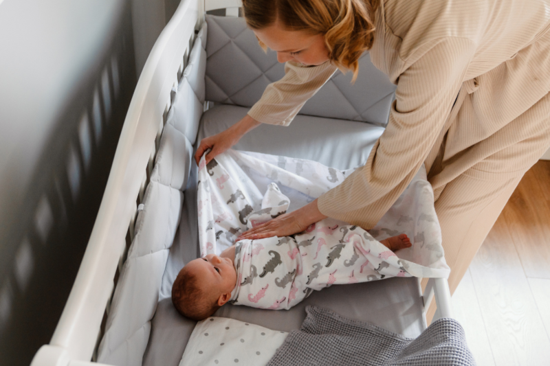Newborn baby swaddled in crub