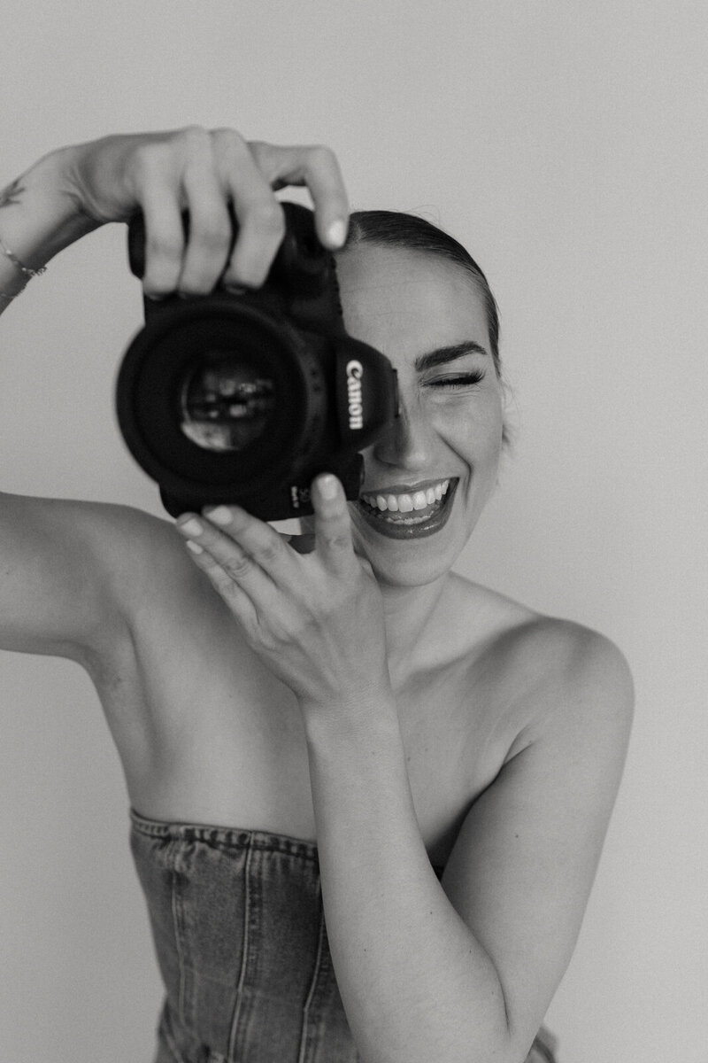 A photographer in a studio with her camera.